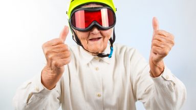 funny grandma wearing a yellow bicycle helmet and ski goggles and showing thumbs up happy habits