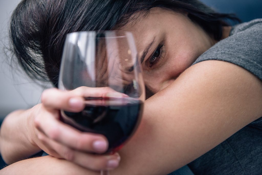 woman in despair with wine in hand, reason to observe alcohol awareness month