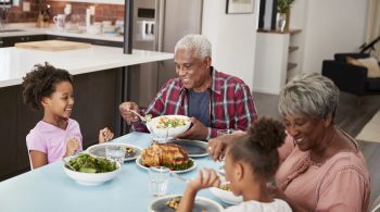 Grandfamilies Enjoying Meal At Home With Granddaughters