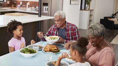 Grandfamilies Enjoying Meal At Home With Granddaughters