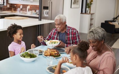 Grandfamilies Enjoying Meal At Home With Granddaughters