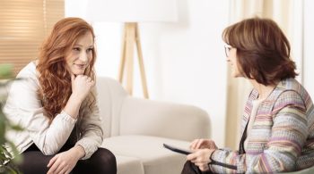 Smiling woman talking to a wellness coach to find support for women in recovery